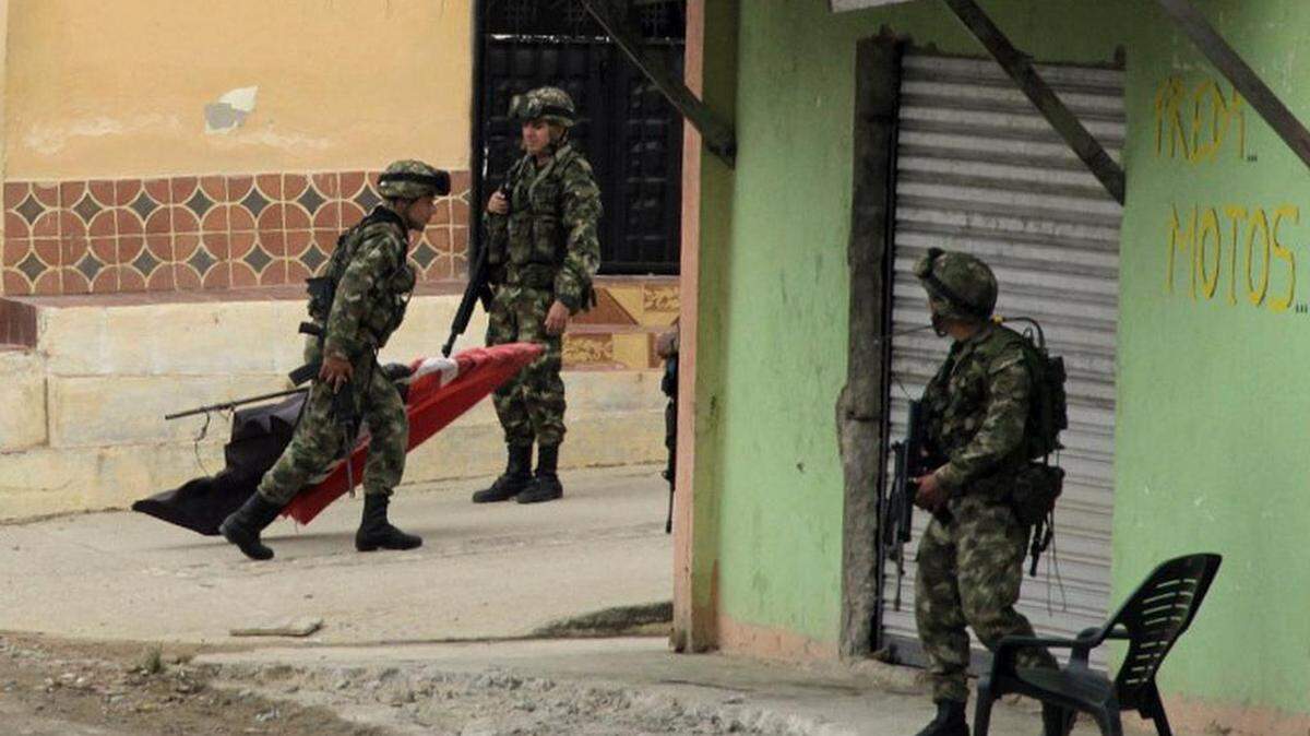 Un soldado colombiano que lleva una bandera de la guerrilla del Ejército de Liberación Nacional (ELN), tras desmontarla de una antena de telefonía celular en la que se encontraba izada hacía varios días en la pobación de El Tarra (Colombia).