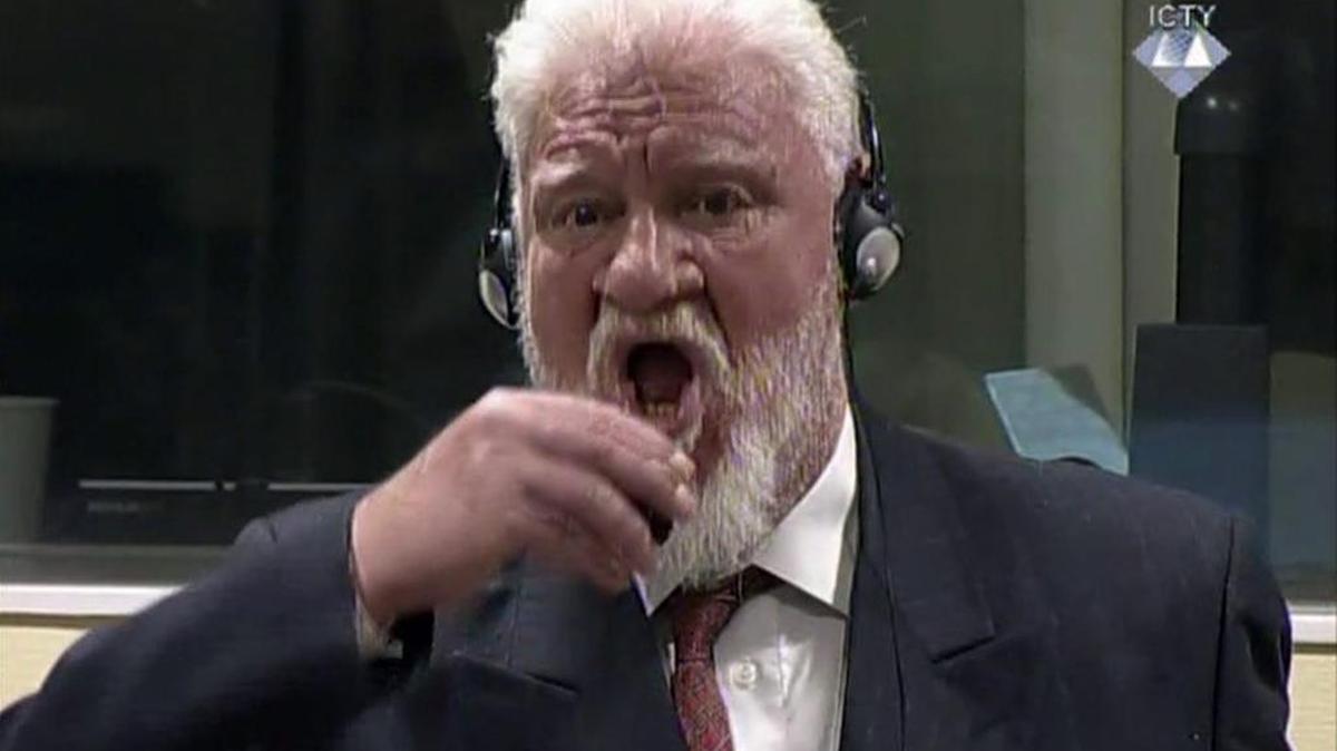 Slobodan Praljak lleva una frasco de veneno a su boca en una audiencia del tribunal de crímenes de guerra, en La Haya, Holanda.