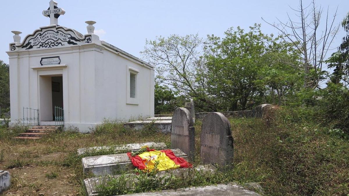 Una bandera de España colocada por unos turistas que visitaron el cementerio militar franco-español de Danang, en el centro de Vietnam, cubre unas tumbas de soldados españoles que lucharon en la guerra de la Cochinchina en el siglo XIX.