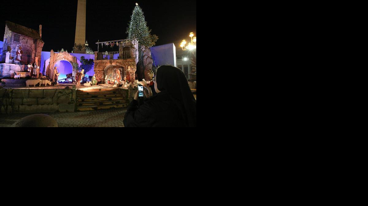 
Una monja hace una foto de un belén, después de que fuese iluminado durante una ceremonia en la plaza de San Pedro del Vaticano, el viernes.
