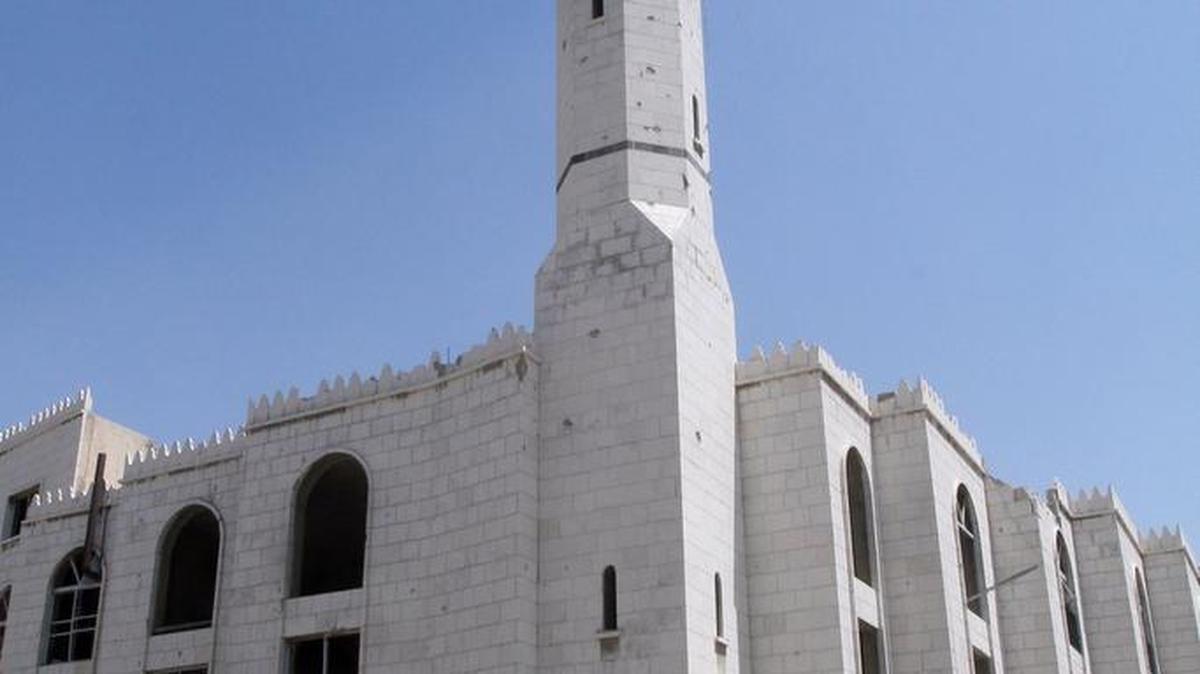 Un soldado camina frente a una mesquita dañada por bombas cerca al centro de Damasco, la capital de Siria.