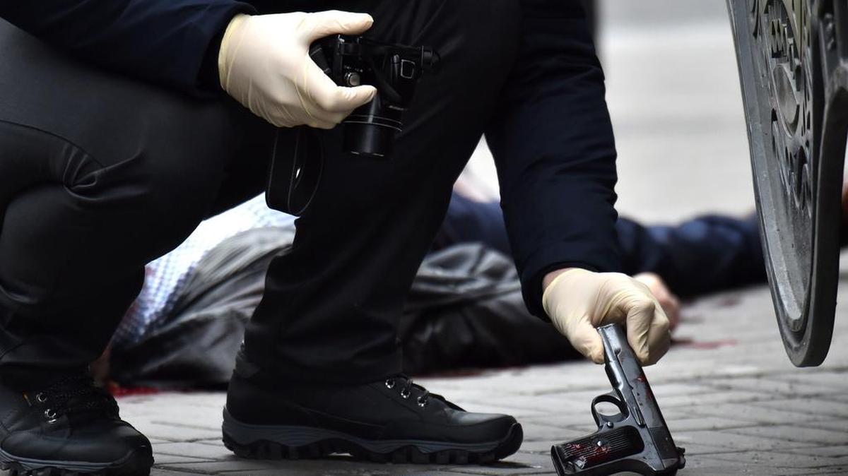 Un experto de la policía ucraniana se apodera de una pistola en la escena donde el ex diputado ruso Denis Voronenkov fue asesinado a tiros el 23 de marzo de 2017 en el centro de Kiev.