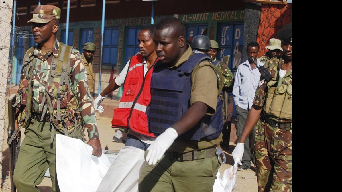 
Policías y miembros de la Cruz Roja llevan los cuerpos de las víctimas del ataque perpetrado por miembros del grupo terrorista Al Shabab en el que la pasada madrugada fallecieron al menos 14 personas en Kenia, el martes. 
