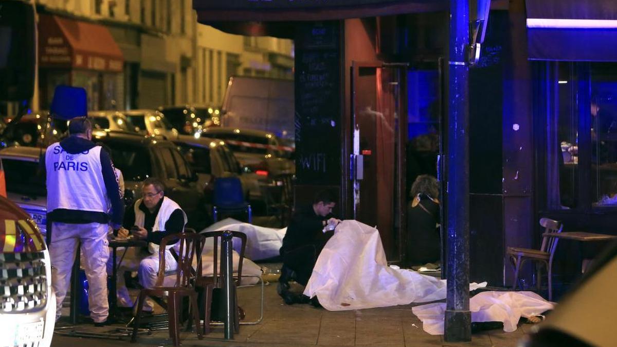 Personal médico examina los cadáveres de varias víctimas en un restaurante de París el viernes.