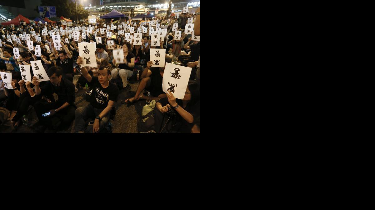 <cutline_leadin>Manifestantes sostienen</cutline_leadin> carteles en los que se puede leer en caracteres chinos ‘Sucia Policía’ durante una manifestación en Hong Kong, China, el miércoles.<252><252>