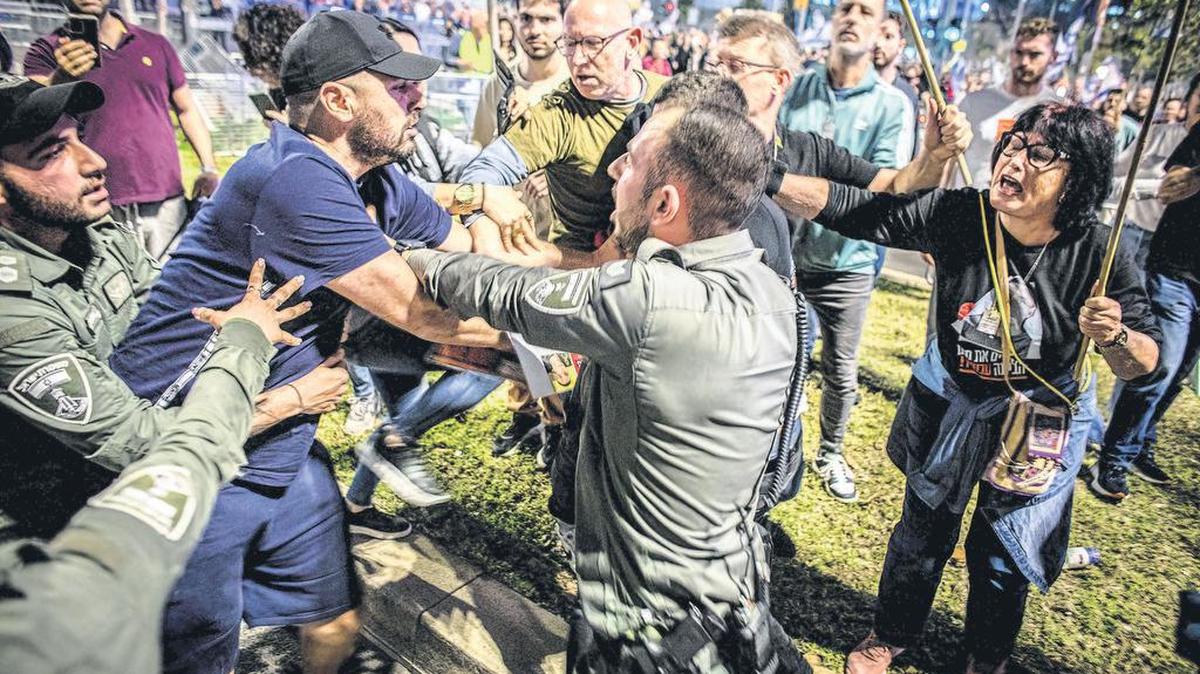 Oficiales de la policía fronteriza israelí rompen una pelea entre un partidario del primer ministro israelí Benjamin Netanyahu, izquierda, y manifestantes anti Netanyahu durante una protesta en Tel Aviv el sábado 30 2024 de marzo.