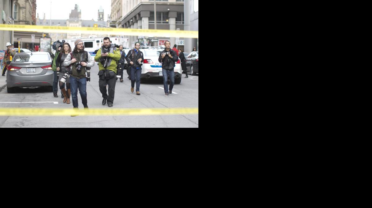 
Un grupo de fotógrafos evacúa mientras miembros del servicio de emergencia aseguran una zona hoy, miércoles 22 de octubre de 2014, cerca a la sede del Parlamento en el centro de Ottawa, Ontario (Canadá). La Policía de Ottawa confirmó oficialmente que un soldado y el supuesto autor de su muerte fallecieron hoy como resultado de los dos ataques que afectaron al complejo del Parlamento de Canadá.
