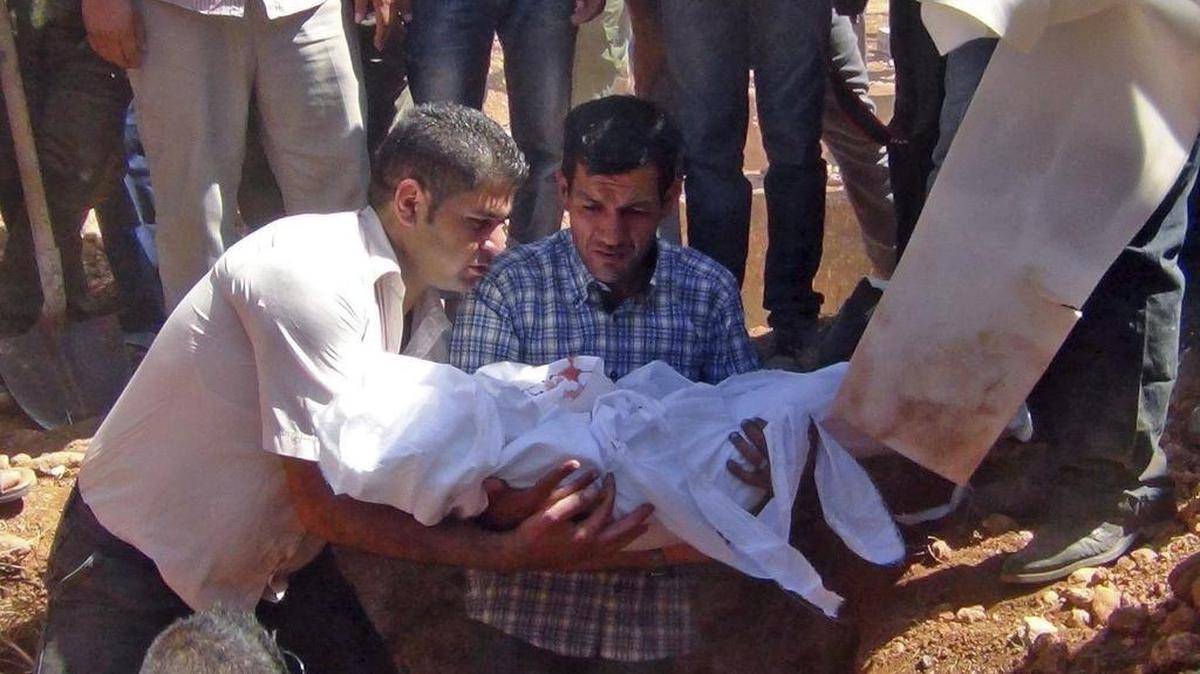 
Abdula Kurdi, centro, padre de Aylan Kurdi, el niño sirio-kurdo de tres años, cuya muerte durante el traslado en bote de Turquía a Grecia se han convertido en todo un símbolo de la tragedia de los refugiados de Oriente Medio, durante el entierro de su hijo en Kobani, Siria.



