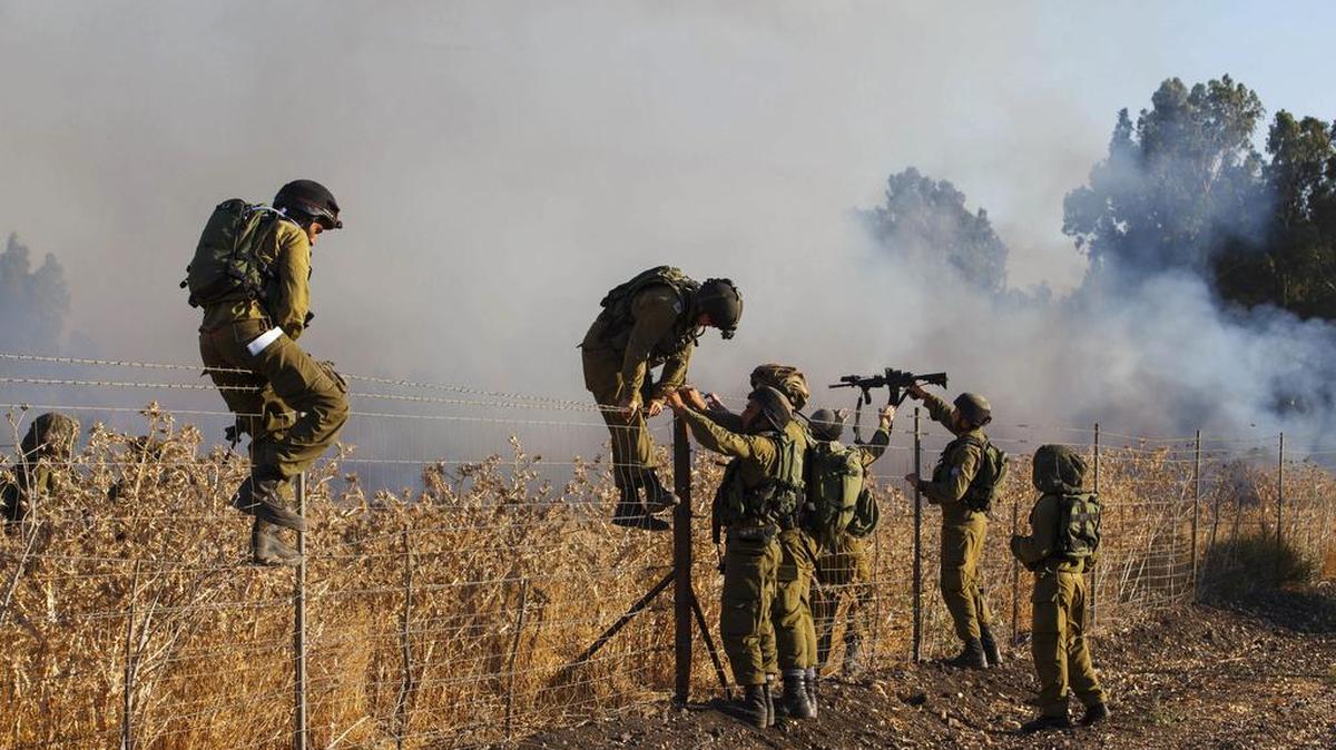
Varios soldados inspeccionan el jueves el lugar del incendio causado por el lanzamiento de misiles desde Siria en Kfar Sold.
