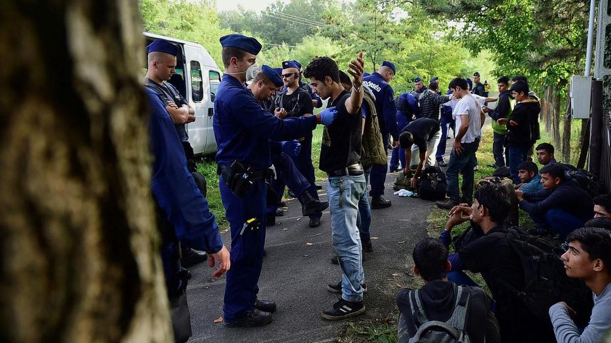 Foto del 17 de septiembre del 2015 muestra a los migrantes siendo detenidos por agentes de policía húngara cerca del pueblo de Ásotthalom cerca de la frontera entre Hungría y Serbia.