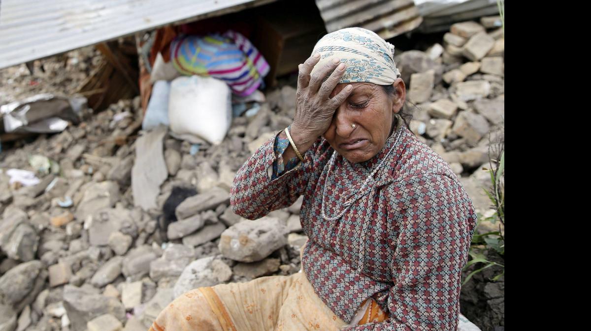 
 Una mujer se lamenta junto a su casa destruída en la aldea de Kumalpur, a las afueras de Katmandú, Nepal, hoy, lunes 27 de abril de 2015. 
