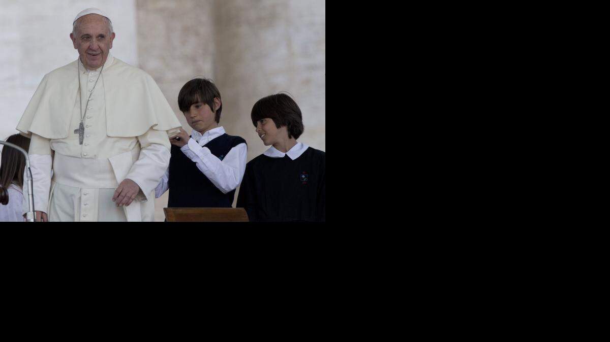 
El papa Francisco con dos estudiantes. La iglesia católica es parte del debate sobre el tema gay en las escuelas italianas.
