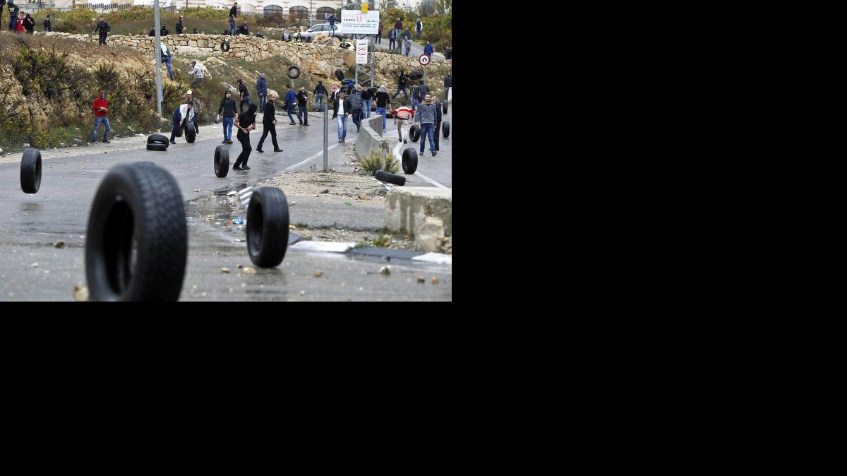 <cutline_leadin>Palestinos arrojan</cutline_leadin> neumáticos a las afueras de Hebrón, Cisjordania, el viernes, mientras se preparan para enfrentarse a las tropas israelíes. La Explanada de las Mezquitas es el tercer lugar más sagrado del islam.<252><252>