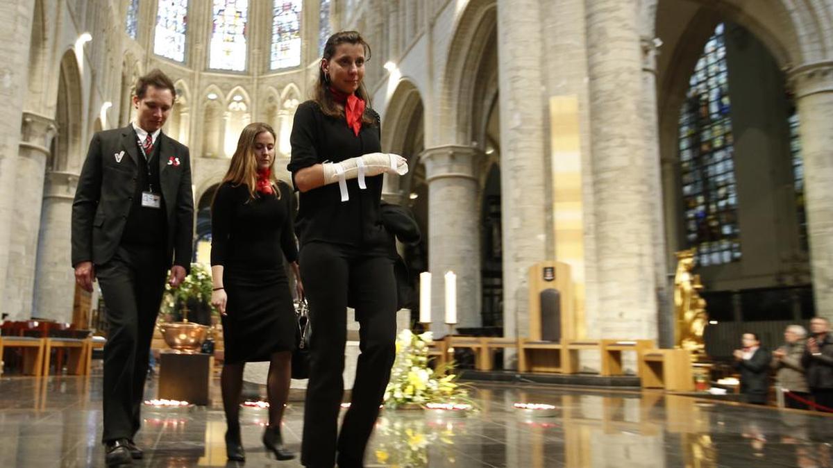 Empleados del Aeropuerto de Bruselas que ayudaron a decenas de víctimas tras los atentados son aplaudidos el lunes en una ceremonia en la Catedral de St. Michael y St. Gudula en Bruselas.