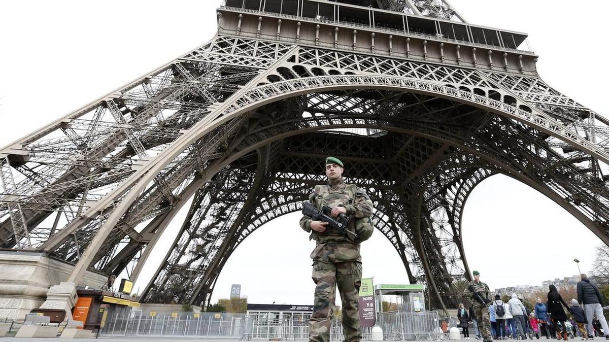 Un soldado bajo la torre Eiffel en París, Francia.