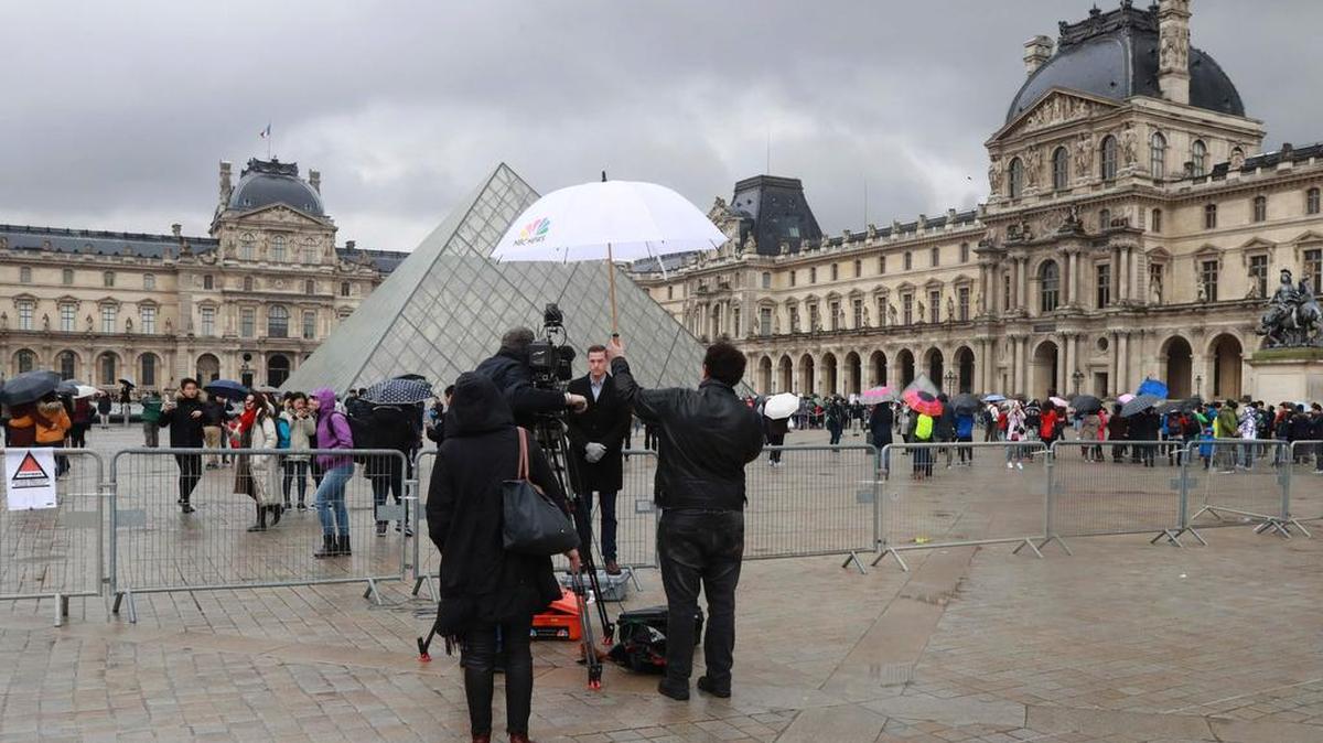 Los periodistas se paran frente a la Pirámide del Louvre en París el 4 de febrero de 2017, un día después de que un hombre con machete atacó a contra cuatro soldados franceses mientras gritaba "Allahu Akbar" ("Dios es el más grande").