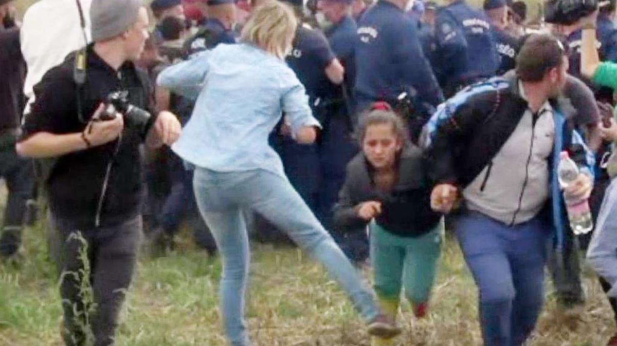 
Imagen de video que muestra el momento en que la camarógrafa húngara Petra Laszlo zancadillea a una niña inmigrante. Laszlo fue despedida por el canal de televisión. 
