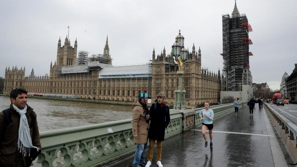 Los turistas toman una selfie en el puente de Westminster con las casas del Parlamento con la torre del reloj del Big Ben, a la derecha, la Torre Elizabeth cubierta de andamios para reparaciones en Londres, el miércoles 31 de enero de 2018.