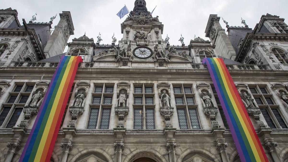 Banderas con los colores del colectivo LGTB decoran la fachada del Ayuntamiento de París, Francia, el lunes 13 de junio de 2016, en memoria de las víctimas de la matanza en un club gay de Orlando, Florida.