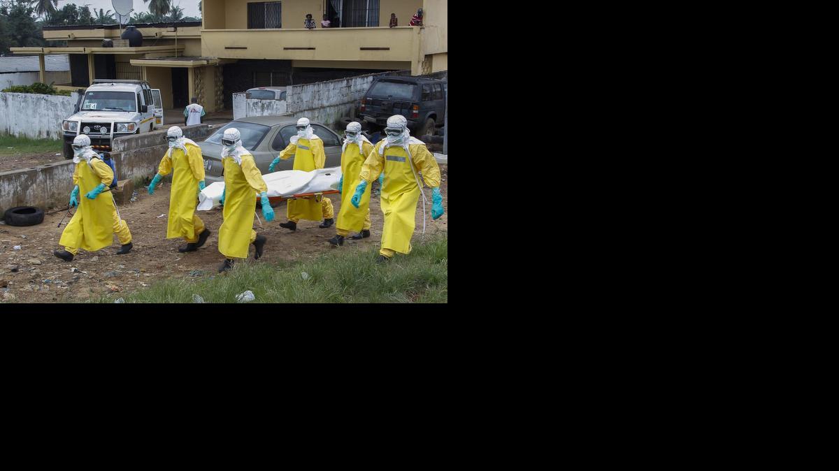 <cutline_leadin>Varios especialistas</cutline_leadin> de salud pública transportan el cuerpo sin vida de una víctima del ébola en Paynesville, a las afueras de Monrovia, Liberia, este martes.<252><252>