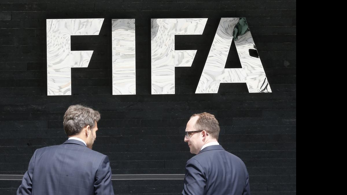 
Dos hombres conversan frente a la sede de la FIFA en Zúrich, Suiza, el miércoles 27 de mayo de 2015.
