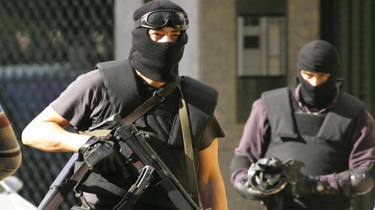 Miembros de las fuerzas especiales policiales españolas controlan el área donde ocurrió un robo por parte de una pandilla, en Sevilla, en el sur de España.
