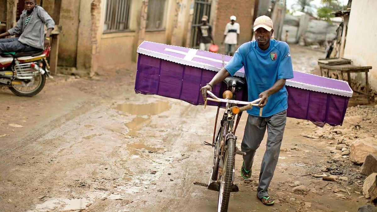 Un hombre carga un ataúd por las calles de Kanyosha, suburbio de Bujumbura, la capital de Burundi, el pasado domingo 10 de enero.