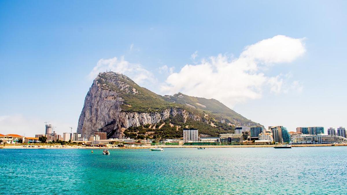 La vida cotidiana en Gibraltar, un territorio de ultramar y promontorio del Reino Unido, en la costa sur de España, conocido por su famoso Peñón de Gibraltar, una cresta de piedra caliza de 426 m de altura, con el Castillo Moro, la Cueva de San Miguel, la guarida de los simios con Barbary monos macacos, Reserva Natural, Teleférico de Gibraltar, El Gran Asedio y Túneles de la Segunda Guerra Mundial.