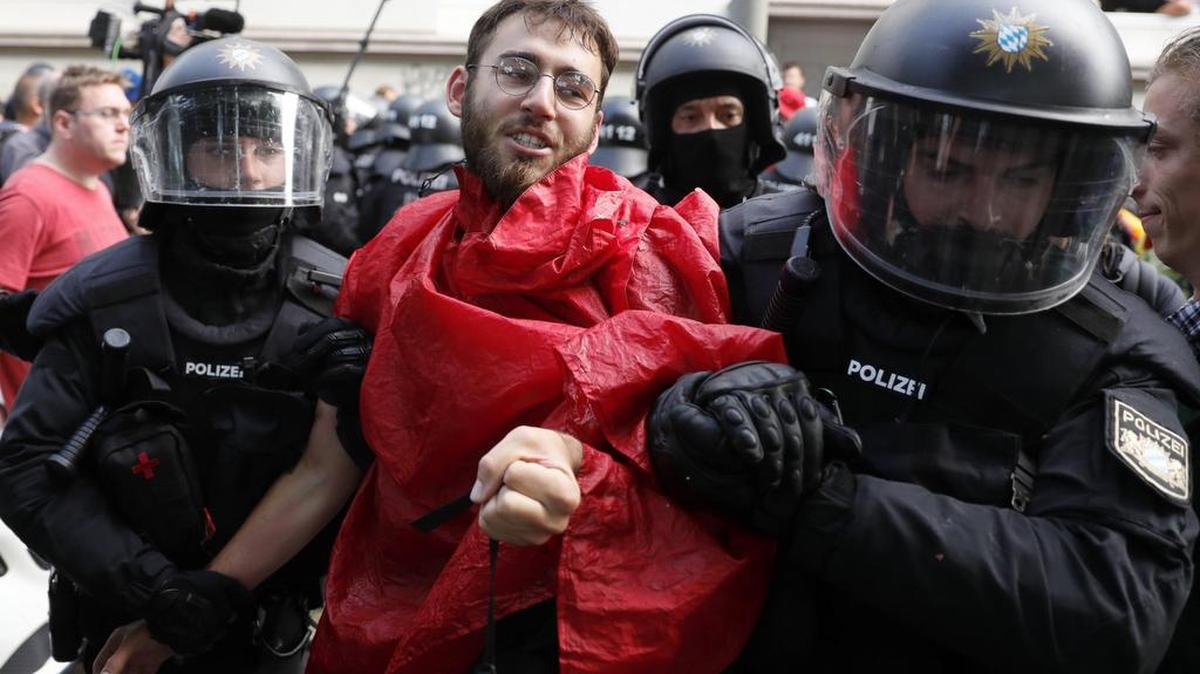 Varios policías detienen a un manifestante delante de la casa de invitados del Senado de Hamburgo donde se aloja el presidente de EE.UU., Donald J. Trump, en Hamburgo (Alemania) el 7 de julio de 2017, día de inauguración de la cumbre del G20.