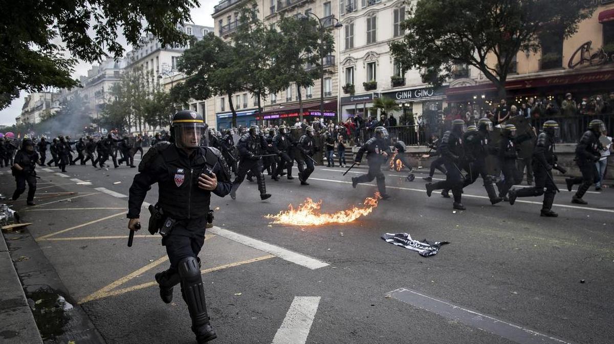 Policías persiguen a manifestantes durante una protesta contra la nueva reforma laboral en París. Los sindicatos franceses han convocado para hoy la primera gran jornada de movilizaciones tras el verano en protesta contra la reforma laboral aprobada por el gobierno.