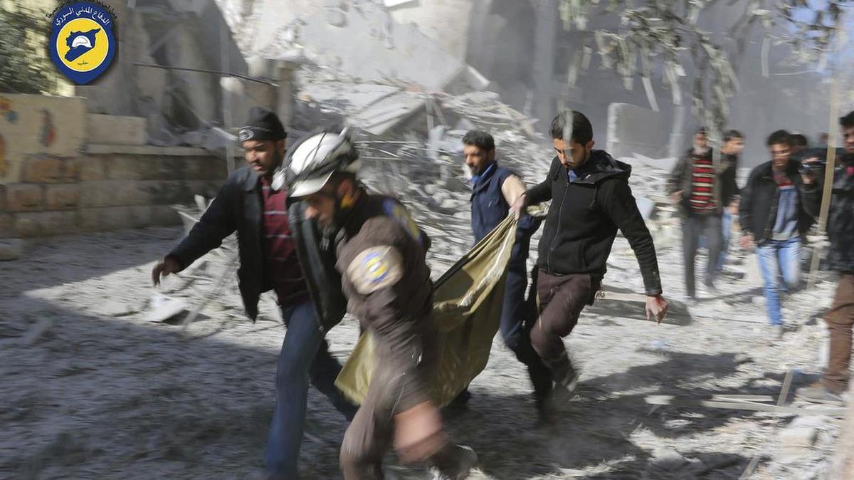 Trabajadores de la Defensa Civil y civiles trasladan un cadaver en Alepo, Siria, el 19 de noviembre del 2016.