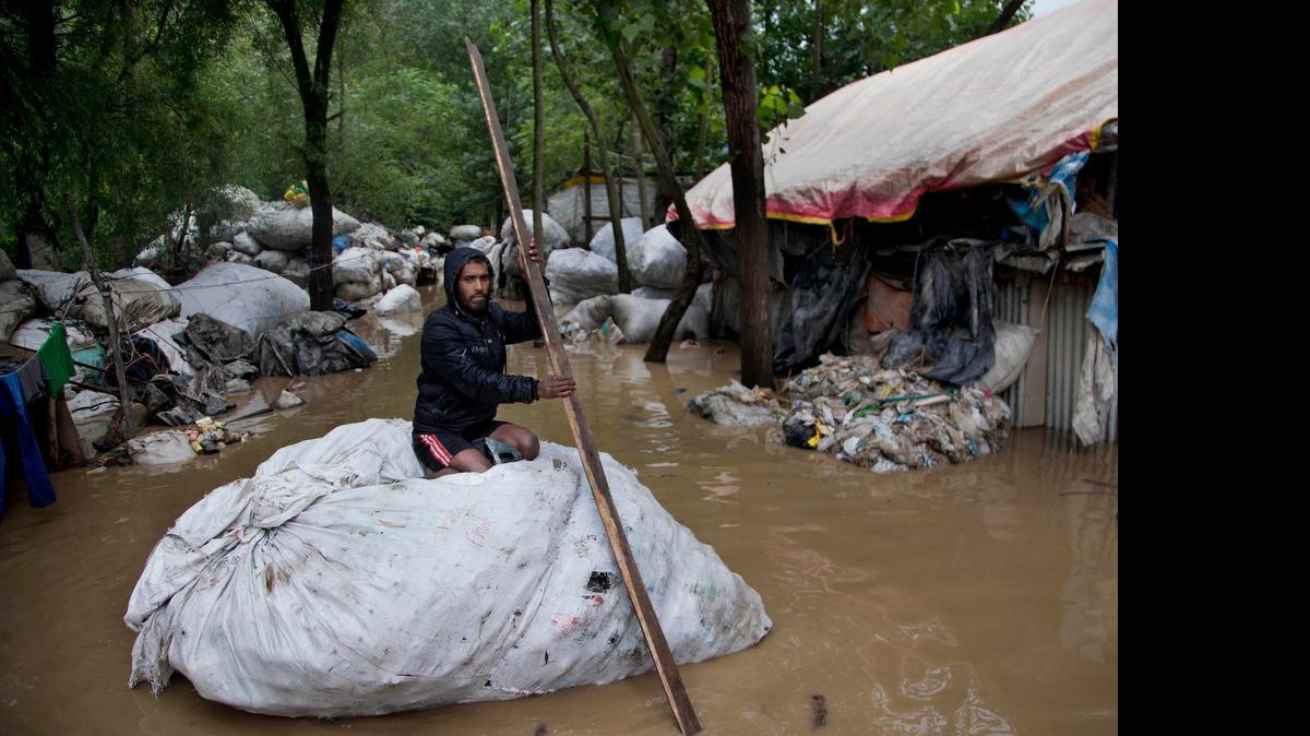 
Un hombre cruza por un vecindario inundado en Srinagar, el jueves. Las inundaciones son habituales en el sur de Asia entre junio y agosto.
