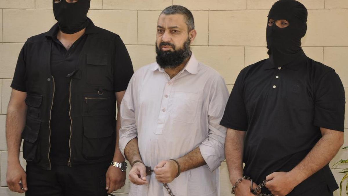 Agentes de las Fuerzas de Seguridad paquistaníes muestran a un militante de Al Qaeda durante una rueda de prensa en Karachi, Pakistán, el viernes.