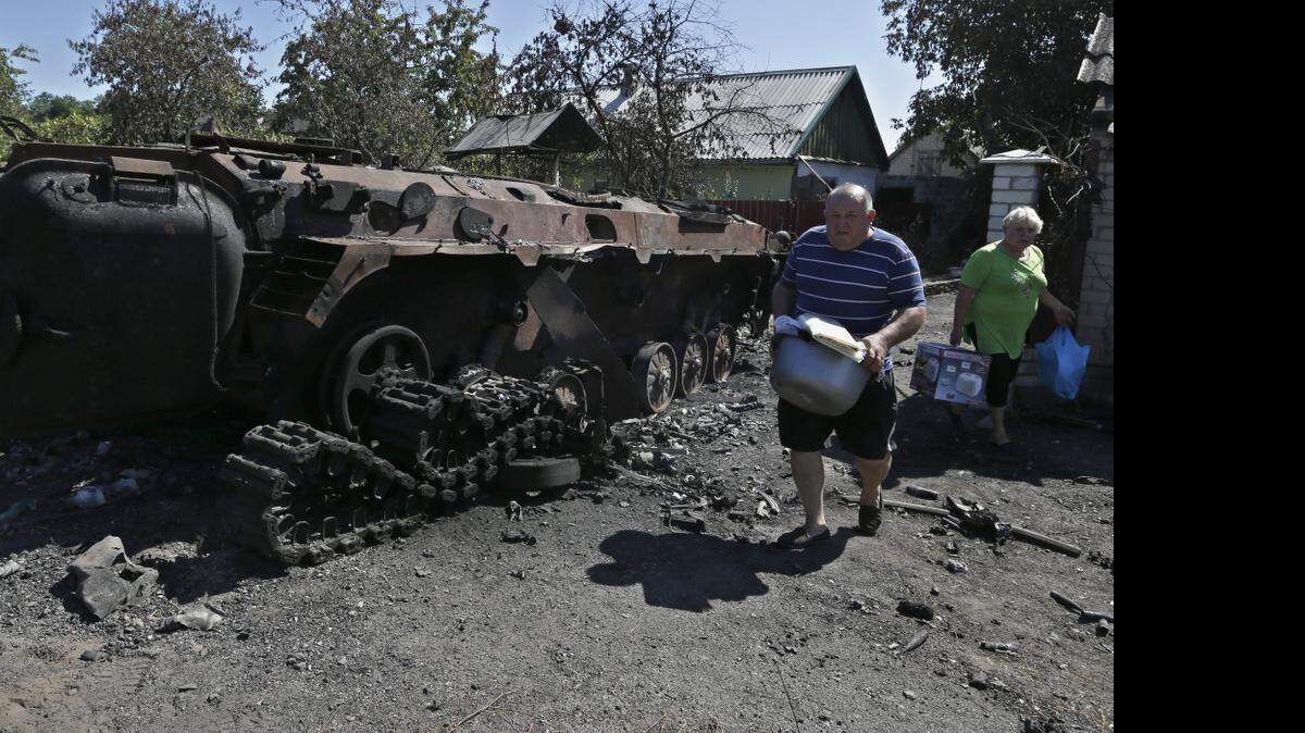 
Habitantes de Hrabske, Ucrania, afectados por la guerra entre el gobierno y los separatistas, huyen de la zona de conflicto con lo poco que pueden llevar.
