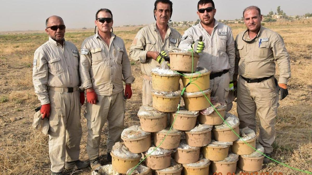 Grupo de kurdos que pertenecen a la Swiss Foundation for Mine Action. Frente a ellos minas hechas por el Estado Islámico que fueron recuperadas y que serán destruidas.