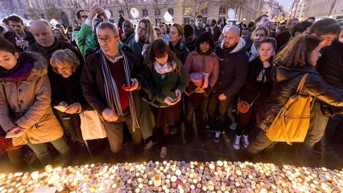 Miles de fraceses acudieron el domingo al centro de París para depositar flores y encender velas por las víctimas de los atentados del viernes en la capital gala.
