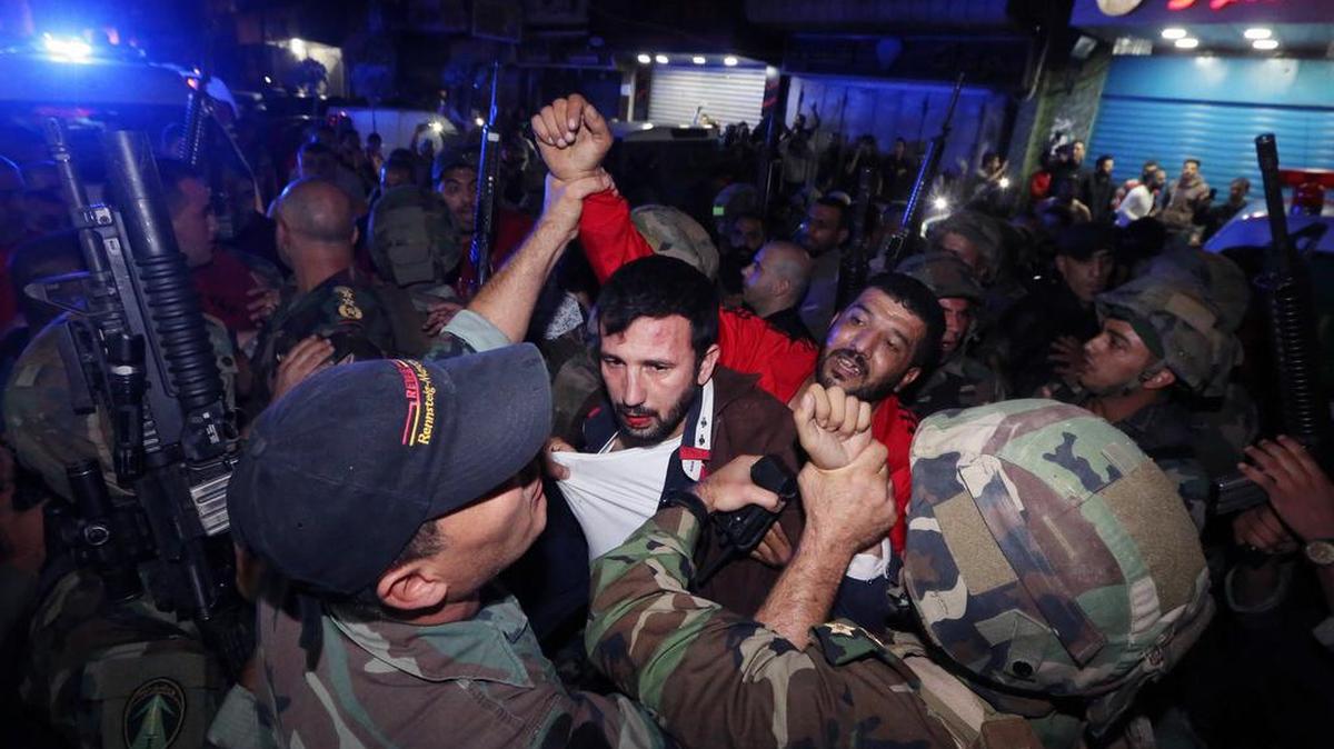 Los atentados suicidas sacudieron el jueves un suburbio del sur de Beirut, un bastión del grupo extremista chiita Hezbolá. En la foto, soldados arrestan a un sospechoso de los ataques.