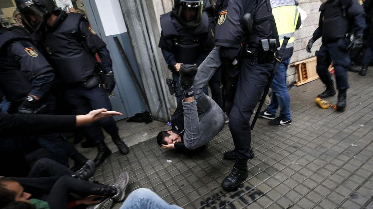 Agentes policiales españoles arrastran a un manifestante de un centro de votación durante el referendo de Cataluña, el domingo en Barcelona, España.