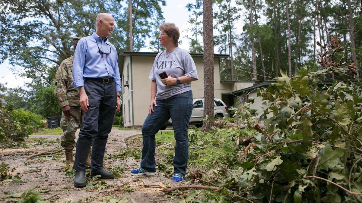 Fotografía cedida en donde aparece el gobernador de Florida, Rick Scott (izq.), hablando con una mujer durante un reconocimiento a poblaciones por donde pasó el ciclón el viernes 2 de septiembre 2016, en Tallahassee, Florida.
