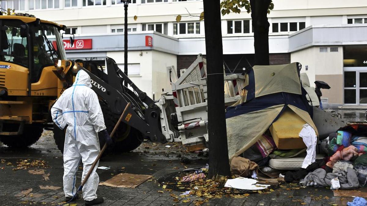 Trabajadores de la ciudad desmantelan el viernes un improvisado campamento de inmigrantes en París.