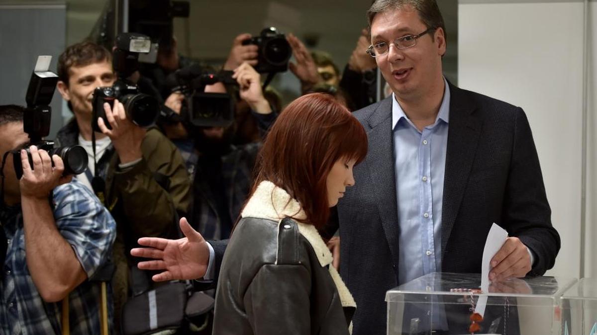 El primer ministro de Serbia Aleksandar Vucic deposita su voto el domingo junto a su hija Milica.