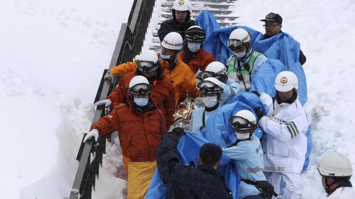 Policías y bomberos evacúan a un estudiante herido en Nasu, prefectura de Tochigi (Japón) el 27 de marzo de 2017 después de que al menos ocho adolescentes fallecieran y otras treinta personas resultaran heridas por una avalancha que sorprendió a un grupo de estudiantes de instituto en una pista de esquí.