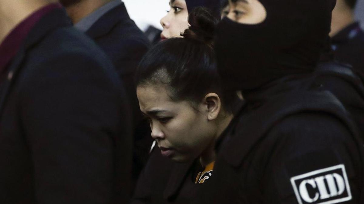 Siti Aisyah (c) de Indonesia y que está siendo juzgada por el asesinato de Kim Jong-nam, el medio hermano distanciado del líder norcoreano Kim Jong-un- es escoltada mientras revisa la escena del ataque en el Aeropuerto Internacional 2 de Kuala Lumpur en Sepang, Malasia, el 24 de octubre de 2017.