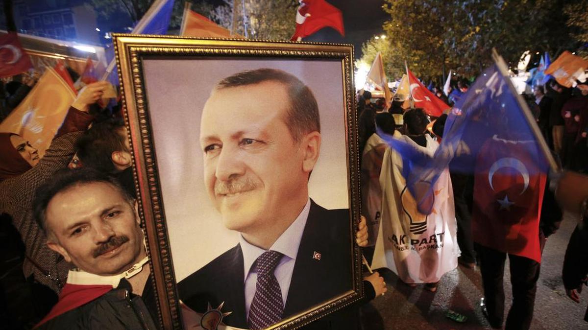 Un seguidor del mandatario turco Recep Tayyip Erdogan muestra una foto del jefe de gobierno.