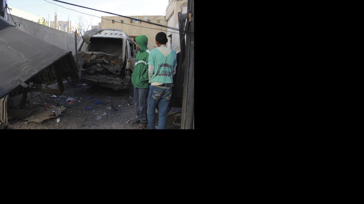 
Varios niños pasan junto a los restos de un vehículo mientras inspeccionan los daños registrados tras la explosión de un artefacto en Saná, Yemen el viernes. 
