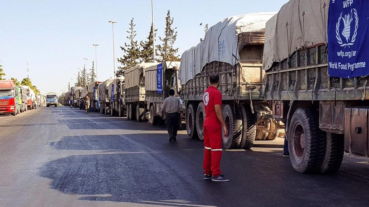 Fotografía cedida por la Media Luna Roja Siria que muestra un convoy de camiones antes de partir para entregar ayuda humanitaria hoy, lunes 19 de septiembre de 2016, en área rural de Alepo (Siria).