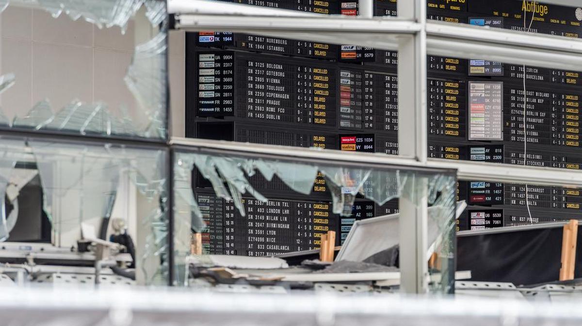 En esta foto del 23 de marzo de 2016, una tabla de llegadas y salida se ve detrás de las ventanas reventadas en el aeropuerto de Zaventem, en Bruselas.