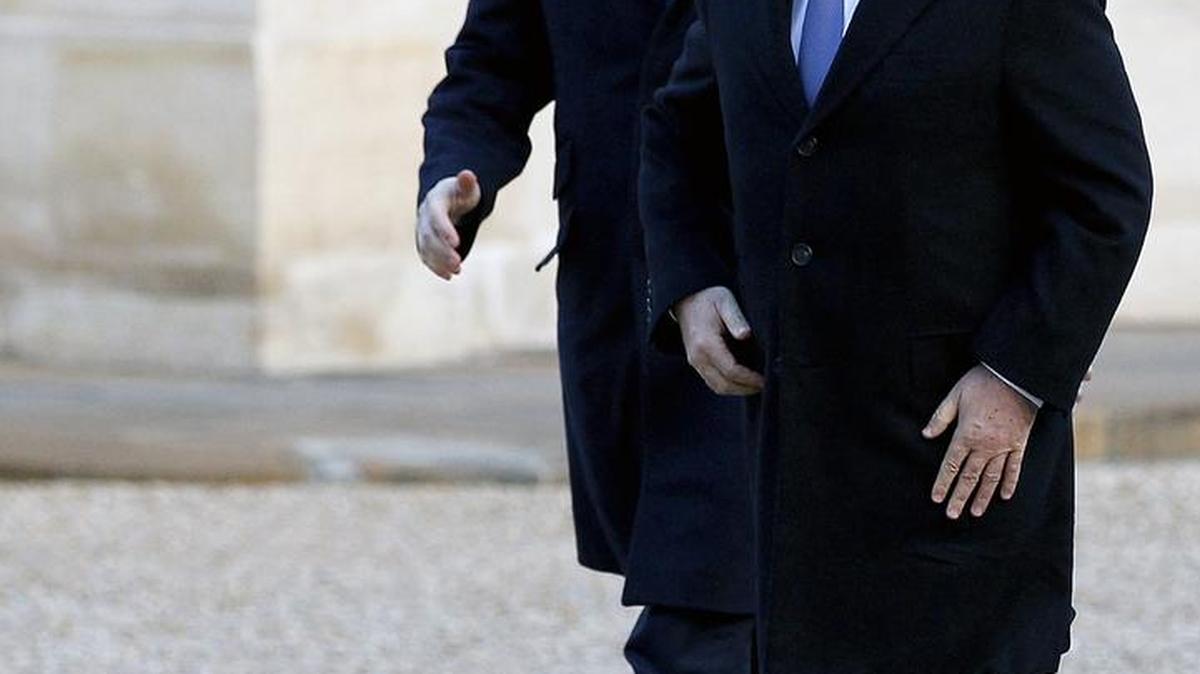 El presidente de Francia Francois Hollande (der.) y el primer ministro británico David Cameron arriban al Palacio Presidencial en Paris para el encuentro del lunes.