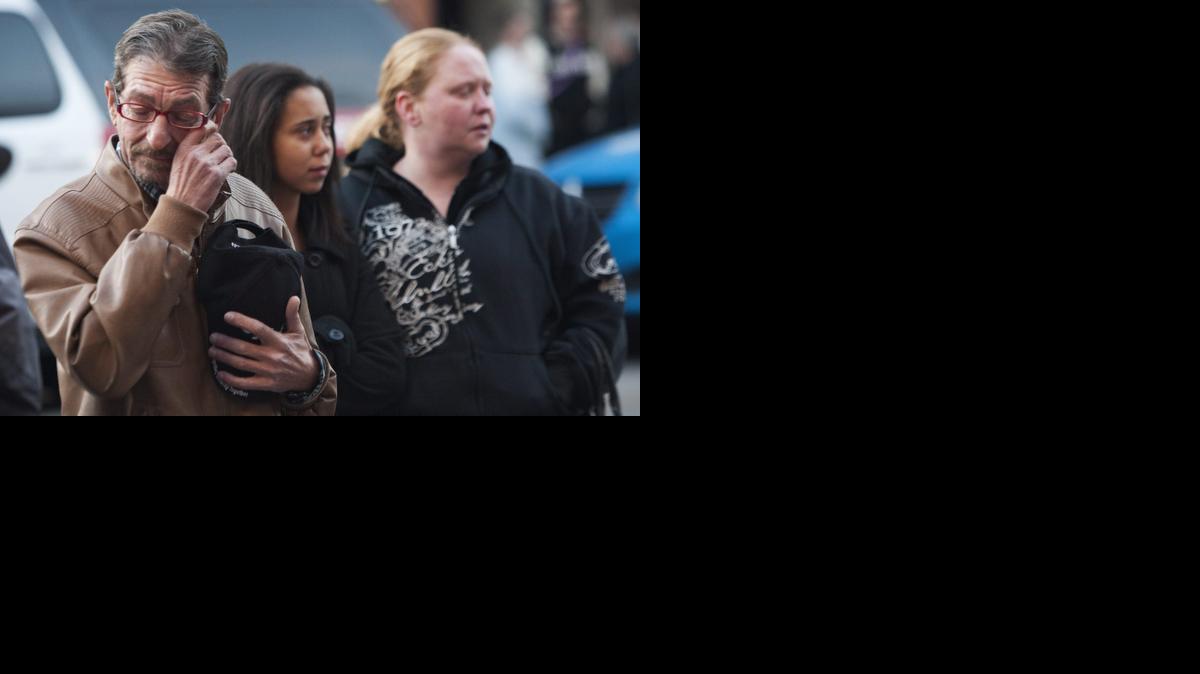 
Consternadas, varias personas observan el sitio donde fue abatido a balazos un soldado canadiense en Ottawa.
