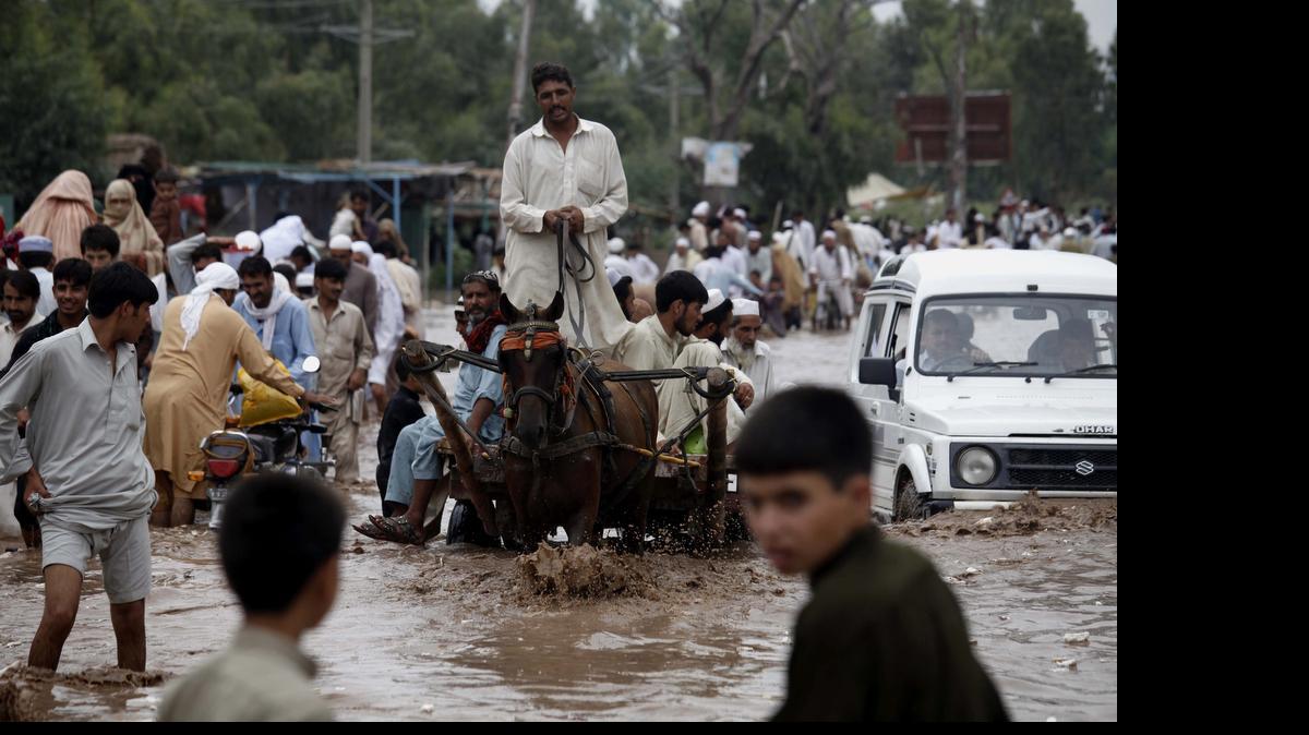 
Las personas tratan de salvar sus pertenencias en las calles anegadas tras las intensas lluvias del monzón en la localidad de Charsadda, en la provincia de Khyber Pakhtunkhwa, Pakistán, el jueves.
